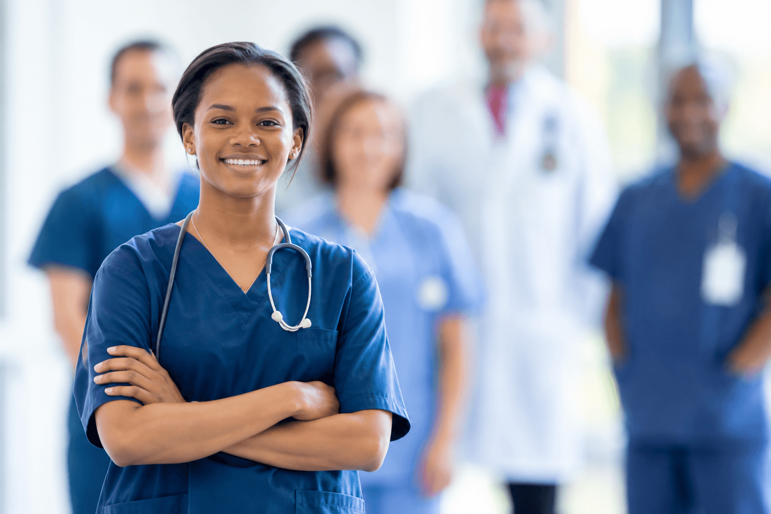 Professional caregiver smiling with a care team in the background